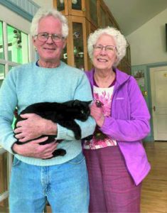 Al and Sherry, holding their black cat